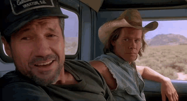 a man wearing a hat that says california on it sits next to another man