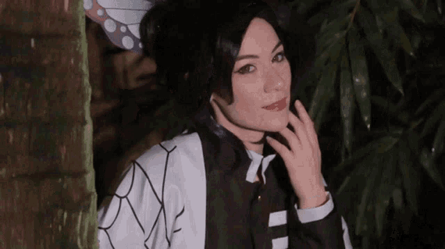 a woman in a black and white costume with a butterfly on her head looks at the camera