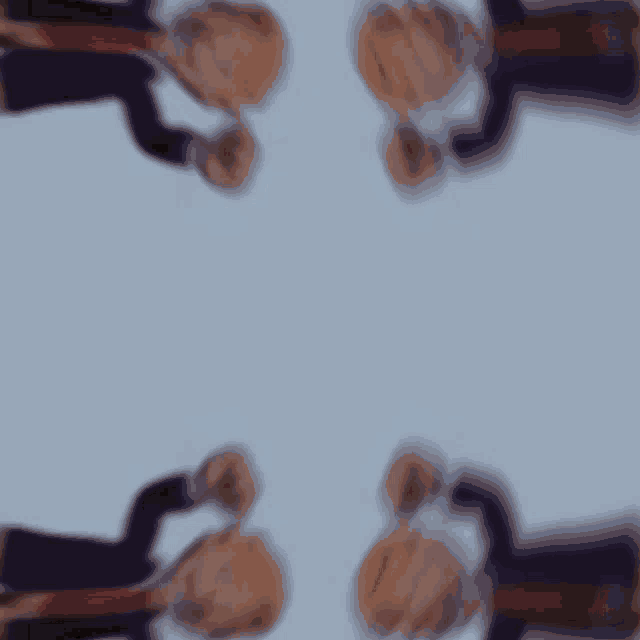 a blurry image of a man in a suit and tie giving a thumbs up