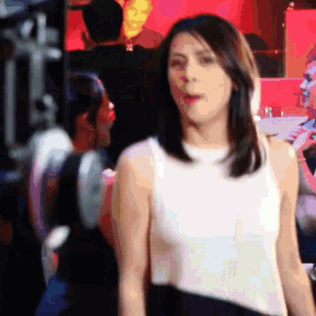 a woman in a white and black dress is standing in front of a red background