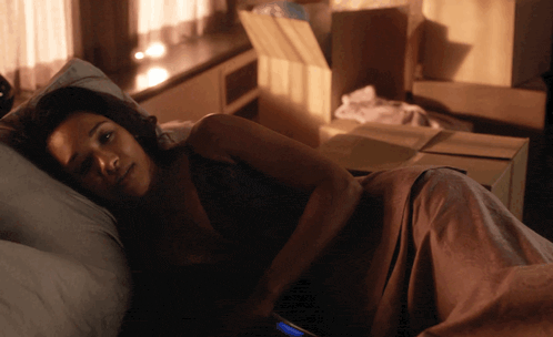 a woman laying on a bed with a phone in her hand