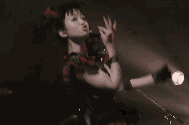 a woman is making a funny face while standing on a stage in front of a microphone .
