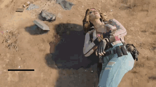 a woman in a pink shirt is laying in the sand