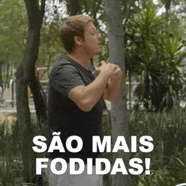 a man stands in front of trees with sao mais fodidas written in white letters