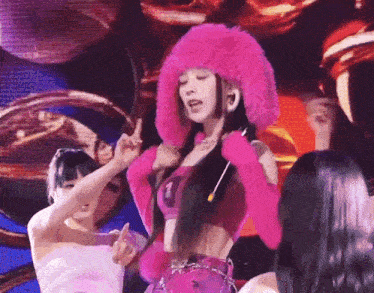 a woman in a pink fur hat is singing into a microphone
