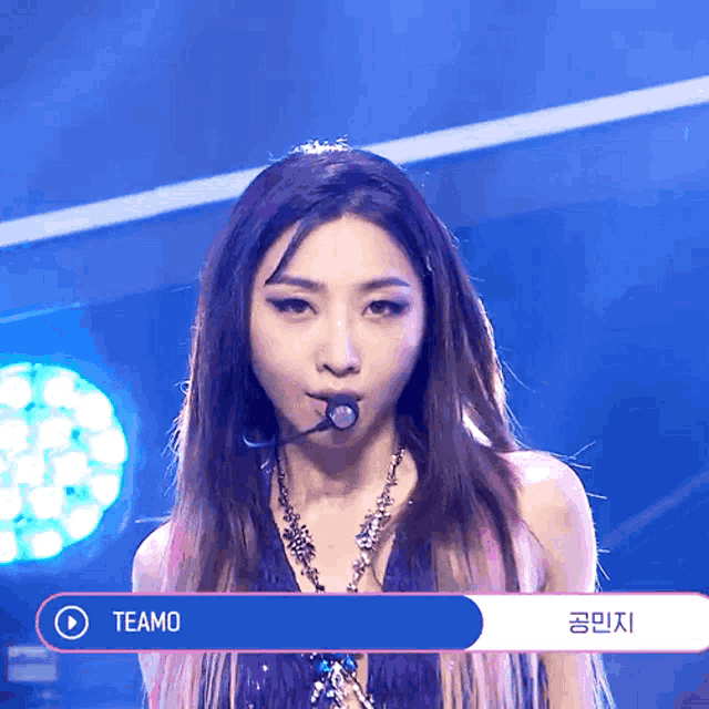 a woman with a microphone and the word teamo on the bottom right