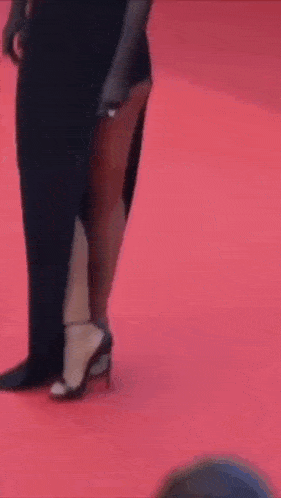 a woman 's legs are shown on a red carpet