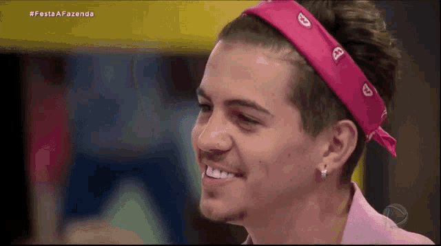 a man wearing a pink bandana on his head smiles