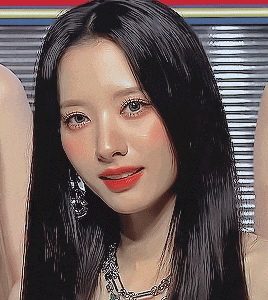 a woman with long black hair and red lips is wearing a necklace .