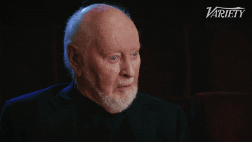 a man with a beard says frighteningly loud in front of a variety logo