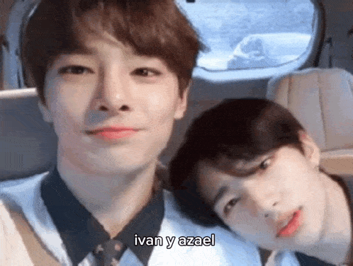 two young men are sitting next to each other in a car and taking a selfie .