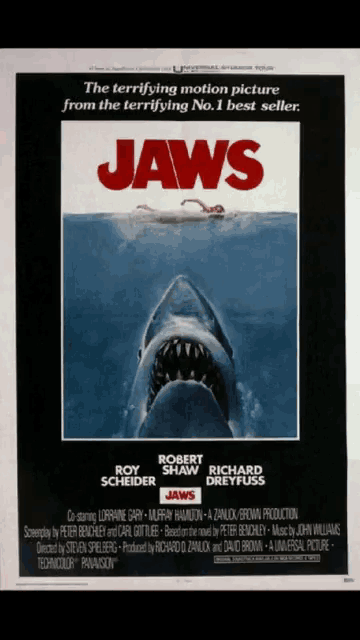 a movie poster for jaws shows a shark in the water
