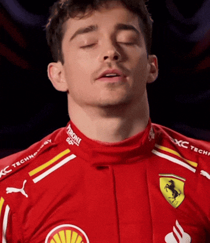 a man with his eyes closed wearing a red ferrari jersey