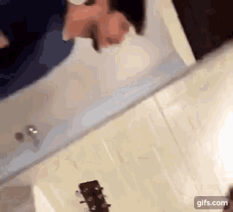 a man is standing in front of a mirror with a guitar in the foreground .
