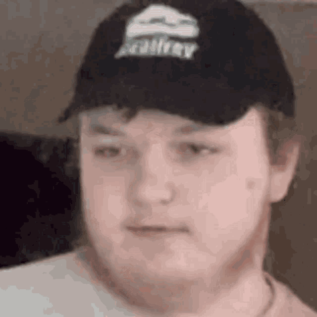 a close up of a man wearing a hat and a white shirt .