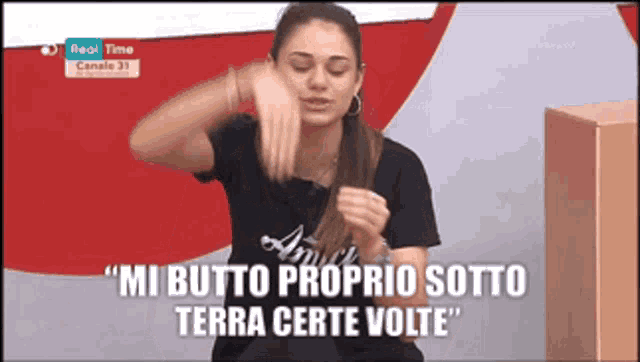 a woman says " mi butto proprio sotto terra certe volte " on a television screen