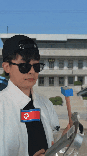 a man wearing sunglasses and a north korean flag patch
