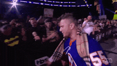 a man wearing a jersey with the number 55 on it walks through a crowd