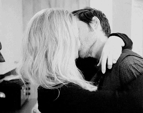 a man and a woman kissing in a black and white photo