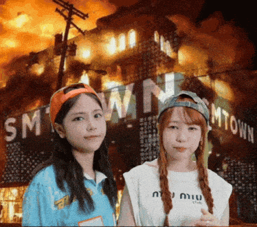 two girls standing in front of a smtown sign