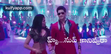a man and a woman are dancing in front of a crowd in a movie .