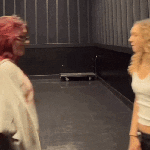 a woman with red hair is standing next to another woman