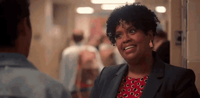 a woman is smiling at a man in a hallway .