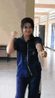 a girl in a blue shirt and pants is dancing