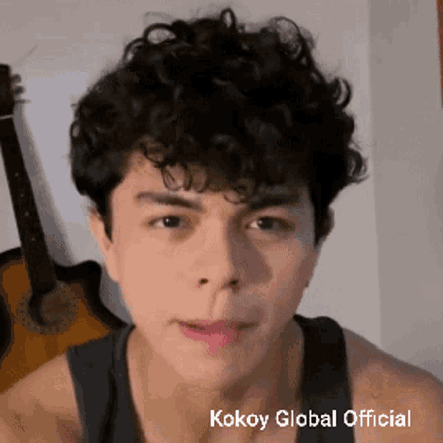 a young man with curly hair and the words kokoy global official