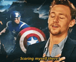 a man in a suit says scaring myself there in front of a picture of captain america