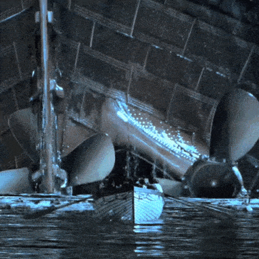 a boat is floating in the water near a ship 's propeller