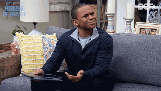 a man sitting on a couch holding a tablet with the house of payne written on the bottom