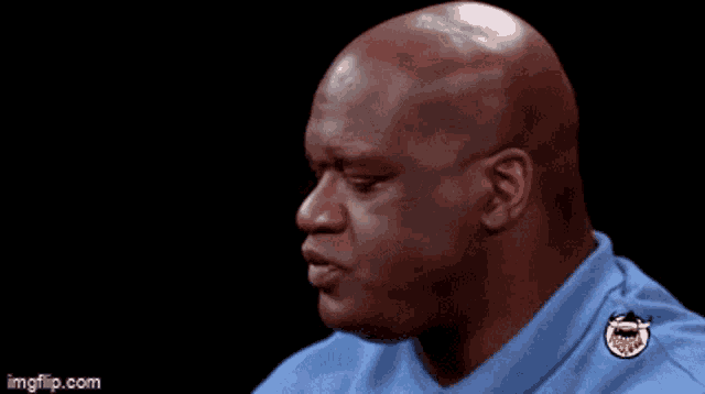 a bald man is wearing a blue shirt with a badge on the collar that says imgflip.com