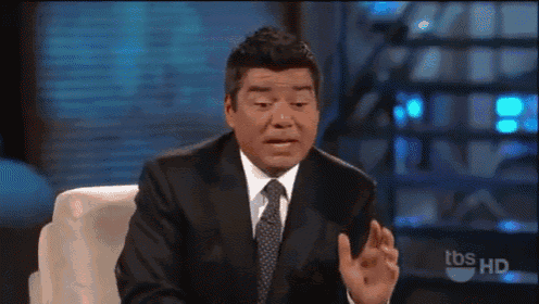 a man in a suit and tie is sitting in front of a television screen that says tbs hd