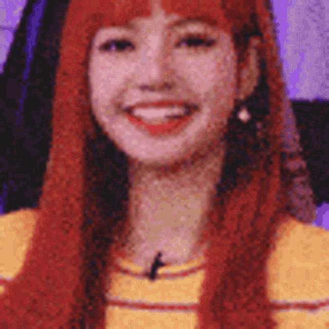 a close up of a woman 's face with red hair and a yellow shirt .