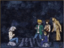 a group of people are standing around a rock in a dark room .