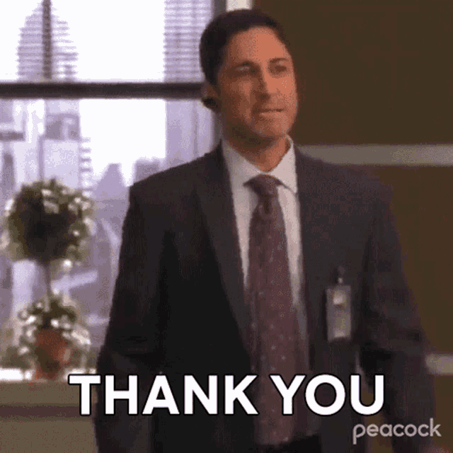 a man in a suit and tie is saying thank you .