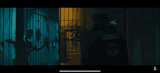 a man in a white shirt is behind bars in a blue room
