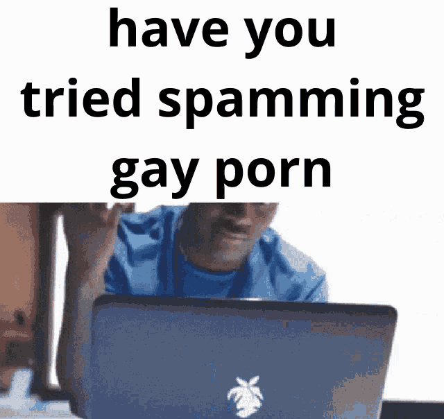a man is sitting in front of a laptop with the words have you tried spamming gay porn written above him .