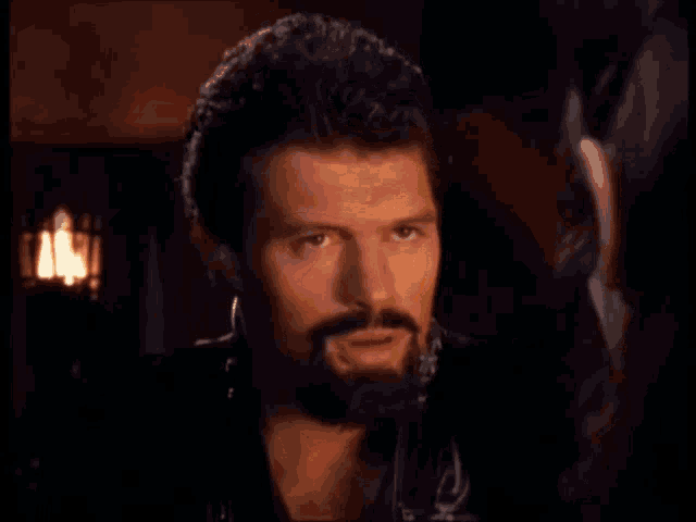 a man with a beard is talking to a woman with burn written in orange