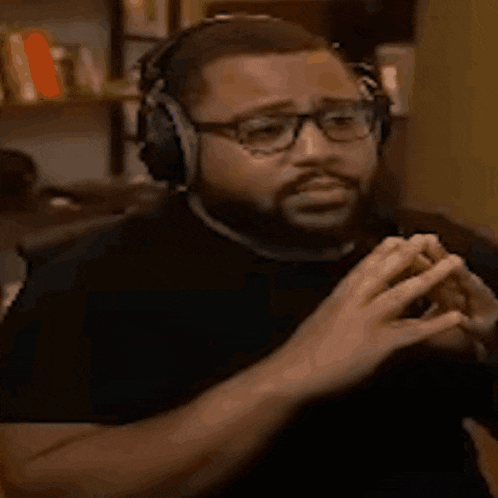a man wearing headphones and glasses is making a face