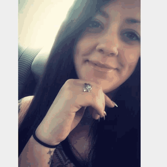 a woman is wearing a ring on her left hand
