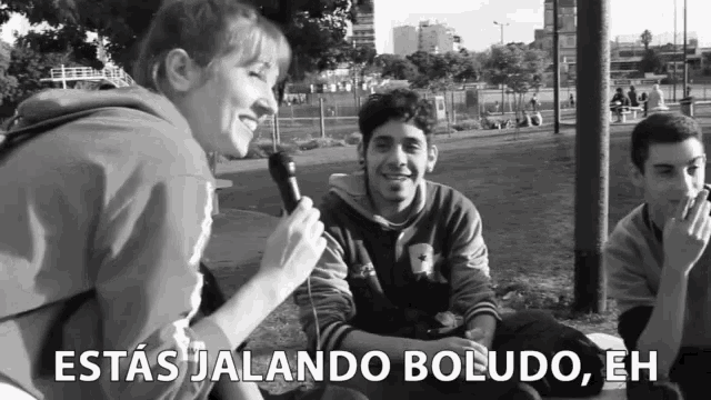 a woman is holding a microphone in front of a group of people and says " estas jalando boludo "