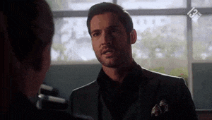 a man in a suit and tie is talking to a woman in a room .