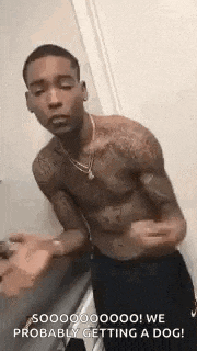 a shirtless man is standing in a bathroom with his arms outstretched .
