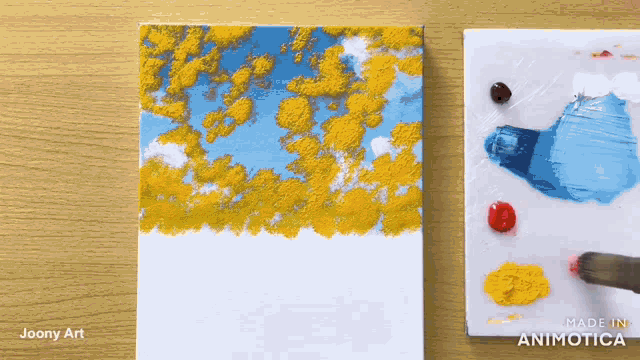 a painting by joony art is shown on a wooden table