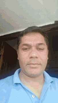 a man wearing a blue shirt with a button on the collar