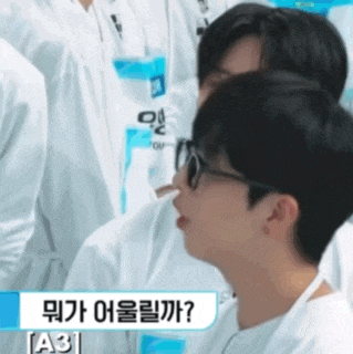 a group of people are sitting in a row and one of them is wearing glasses and a name tag that says a3