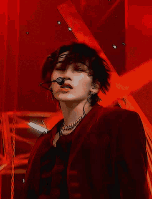 a close up of a person wearing a microphone and a red jacket