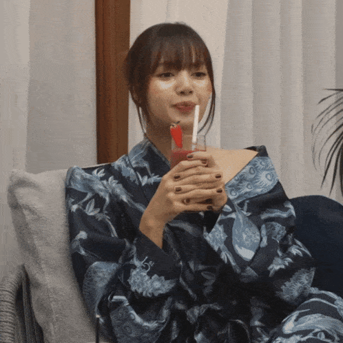a woman sitting on a couch with a drink in her hand